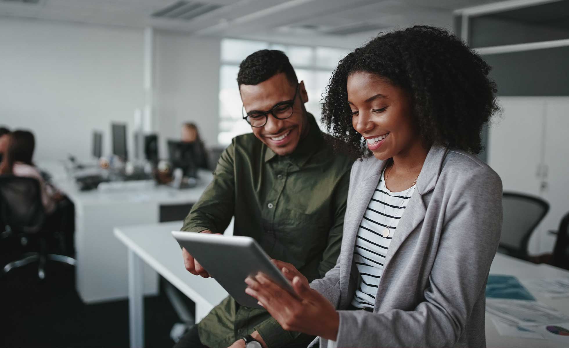 two coworkers looking at a tablet