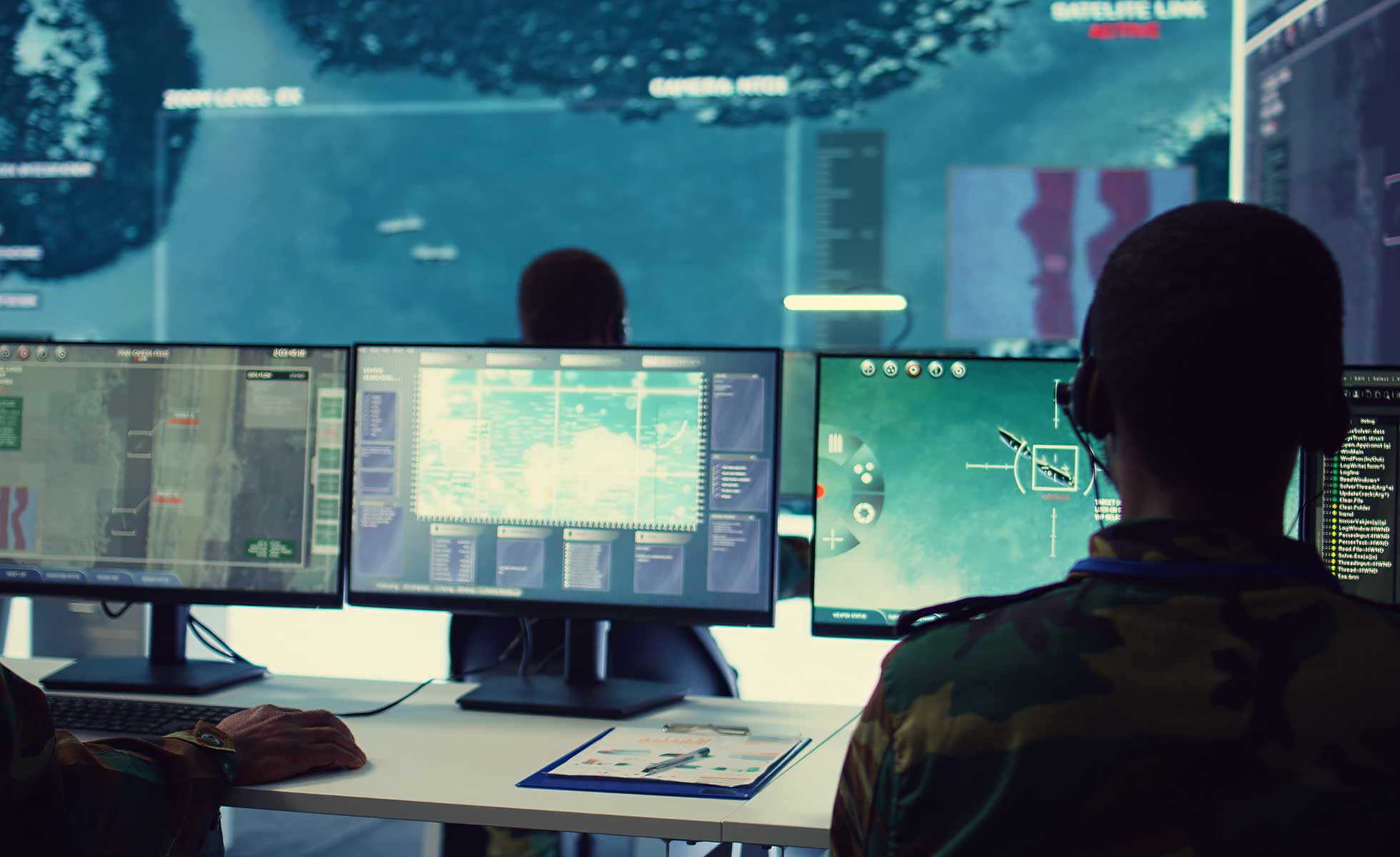 workers looking at computer monitors with drone footage and digital maps